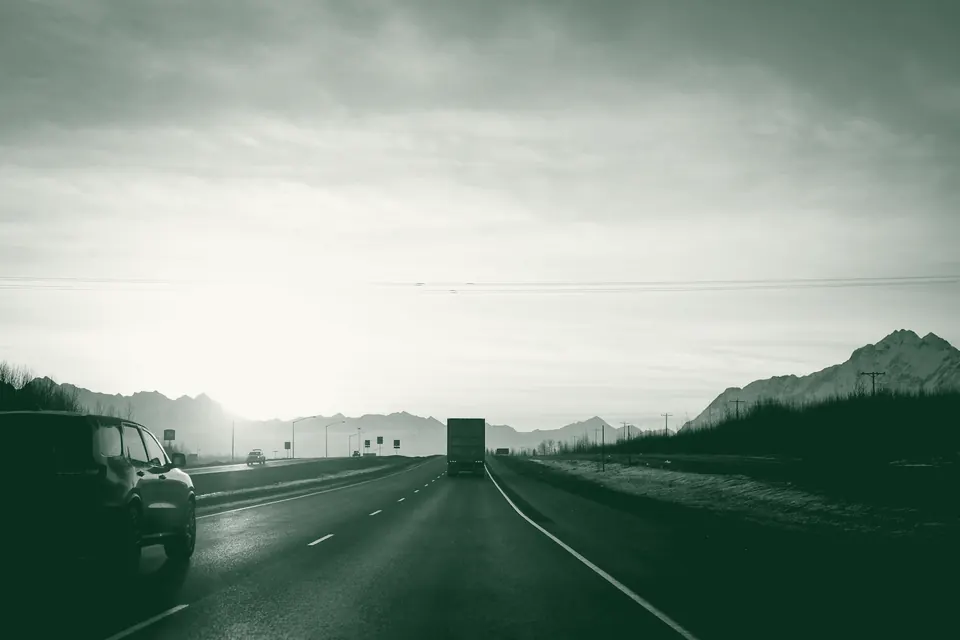 Camión articulado circulando por una carretera al atardecer